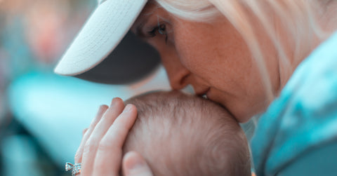 mom kissing babies head