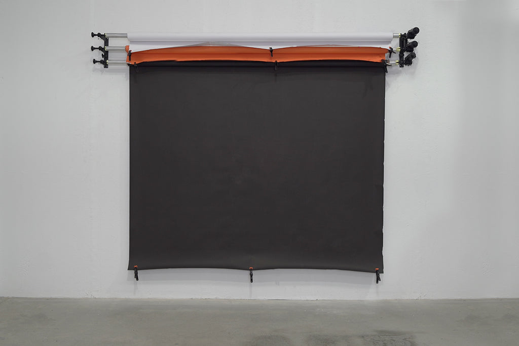 A white, dark brown and orange backdrop on a triple backdrop wall mount 