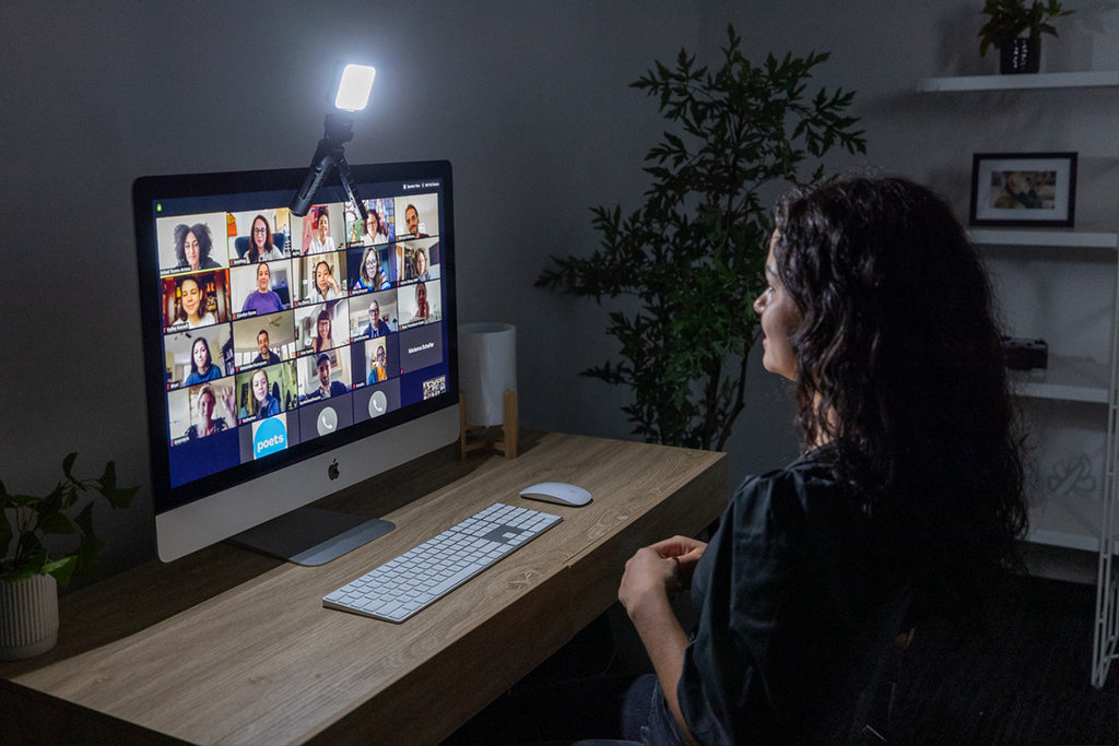 Woman sitting at desk smiling during a conference call on her computer