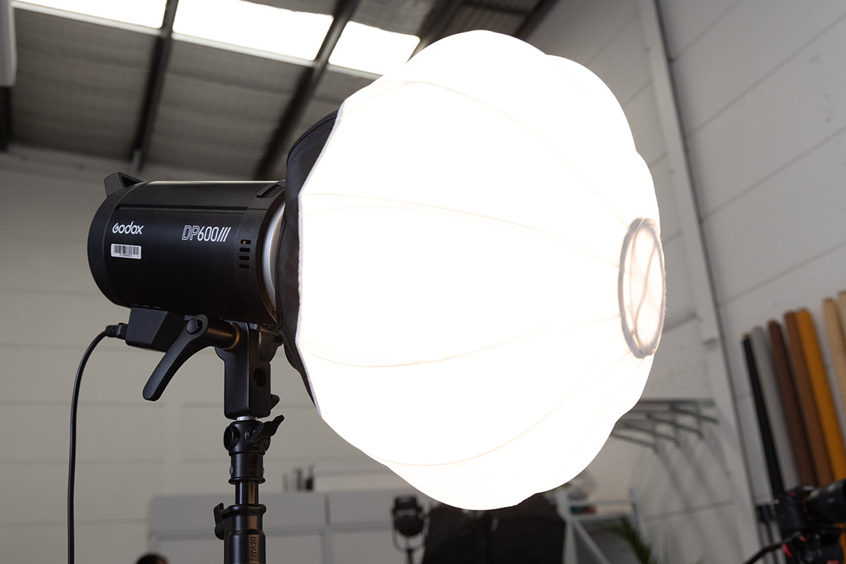 An image of a Godox DP600III lantern softbox illuminated with a warm, diffused light. 