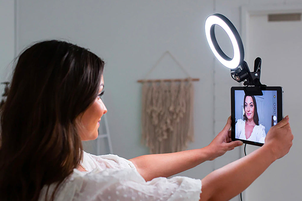 Woman holding up iPad tablet with Small Selfie Ring Light Attached