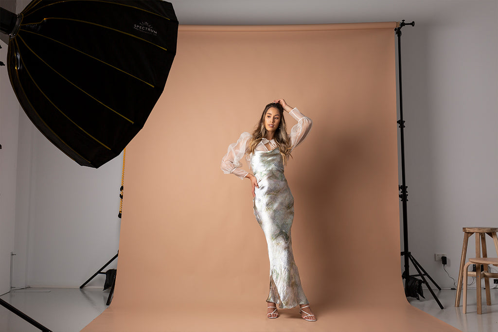 Woman posing in front of a brown backdrop