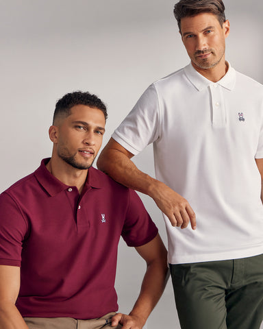 two models wearing psycho bunny's crimson and white polo one standing the other sitting down