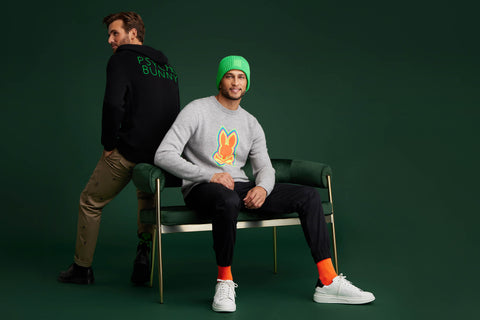 green background with two models wearing sweaters