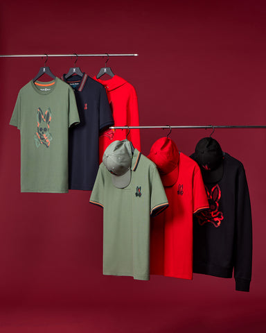 graphic tees shirts in khaki red and black and polos in khaki red and black hanging on a crimson background