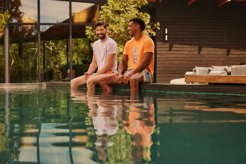 deux gars avec les pieds sur l'eau au bord d'une piscine