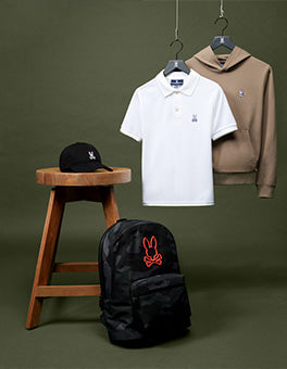 a psycho bunny polo in white, hoodie in beige, a back pack and a cap