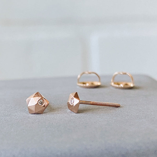 A pair of rose gold micro fragment studs with threaded ear posts.