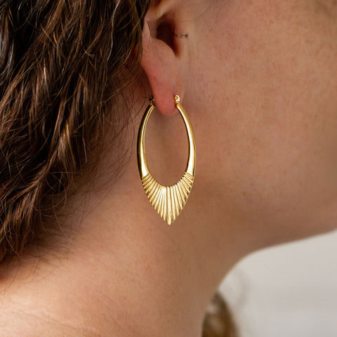 Large gold petal shaped sunburst hoop earrings with hinge closure