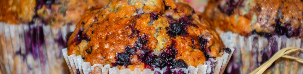 A closeup of veggie blueberry muffins with paper muffin cups.