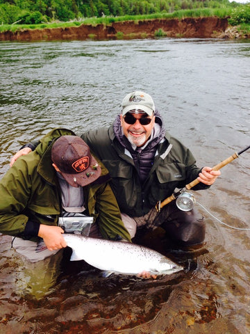 Two fishermen with large salmon