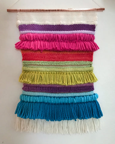 This is a multicoloured woven wallhanging where different yarns and colours have been used to create pattern