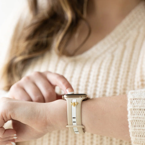 A stylish young woman in a cafe, looking at her wrist as if wearing a watch.