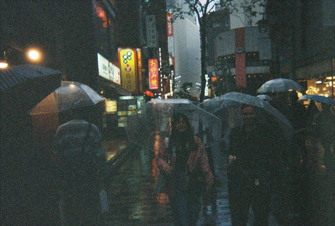 Isabella Schimid daughter in raining Shinjuku, Tokyo holding an umbrella at nighttime