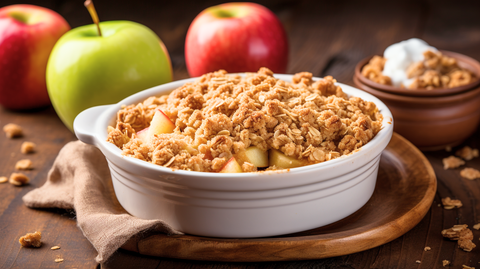 A freshly baked apple crisp nestled in a charming ramekin, elegantly presented on the table alongside crisp, fresh apples.