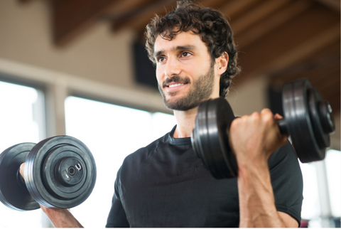 A fit man confidently lifting dumbbells in both hands