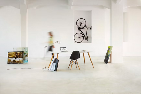 Na imagem, uma bicicleta enconstada na parede, com uma pessoa andando