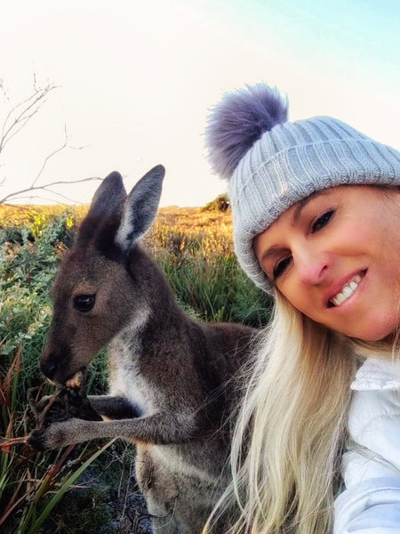 selfie of tania from anything and everything esperance  with a kangaroo eating  vegetation at lucky bay esperance