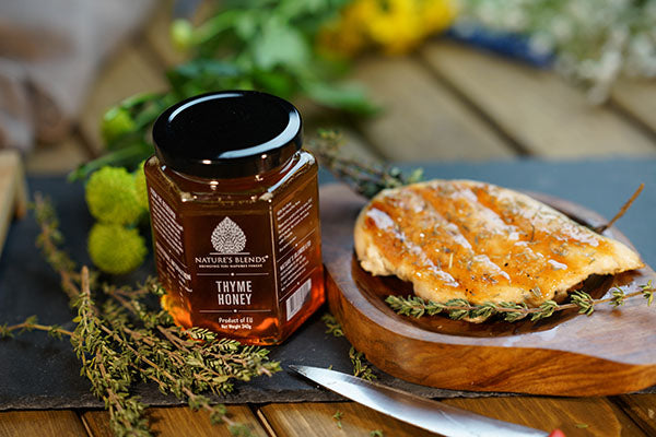 Two jars of organic thyme honey with some bread 