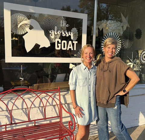 "Owners of The Glossy Goat posing in front of the store, embodying the essence of fun, fashion, and warmth at our beloved boutique."
