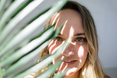 Pure & Coco | Woman behind a leaf casting a shadow on her face