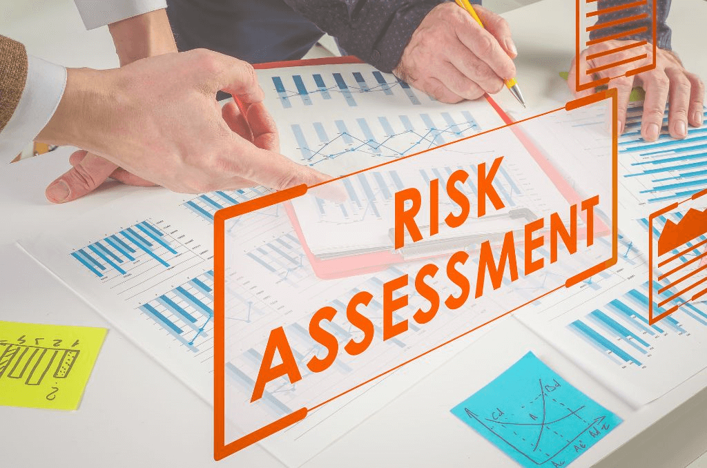 Risk assessment paper sitting on a table with a team of people working 