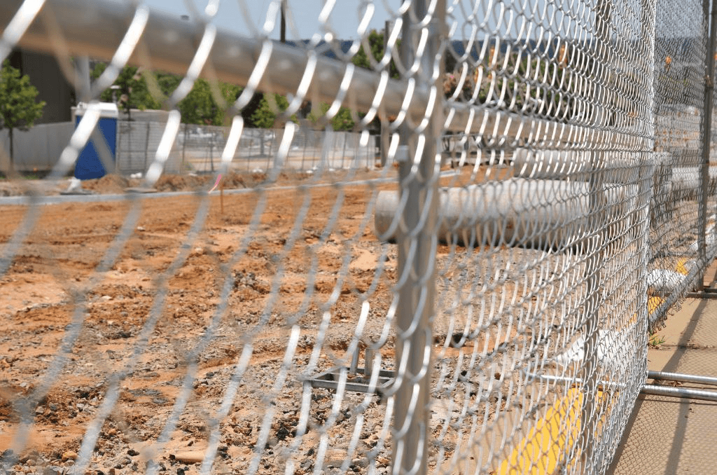 shot of a fence at a construction site with materials in the background
