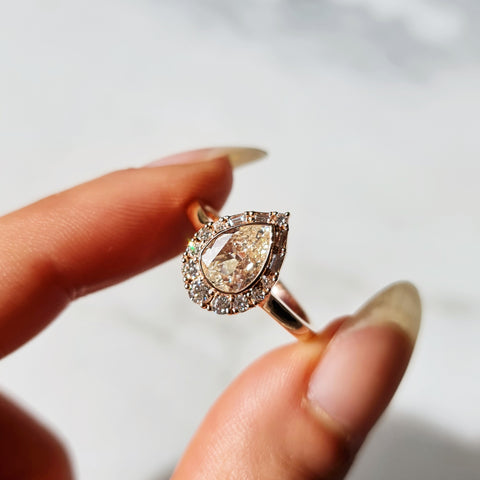 Rose gold halo engagement ring with antique pear cut centre stone