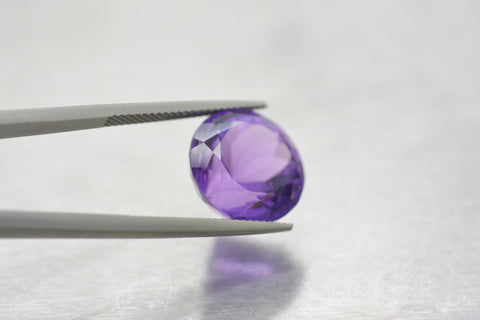 Amethyst Stone held by a tong.