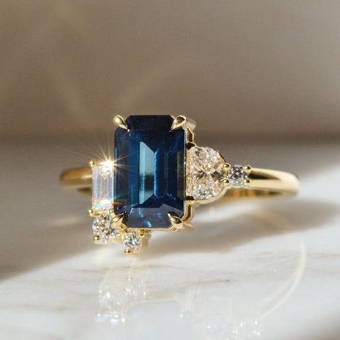 A Ring with Sapphire Stone placed in the white surface.