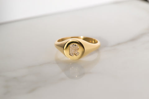 A Gold Signet Ring featuring custom cut diamond letters designed by Layla Kaisi Collection