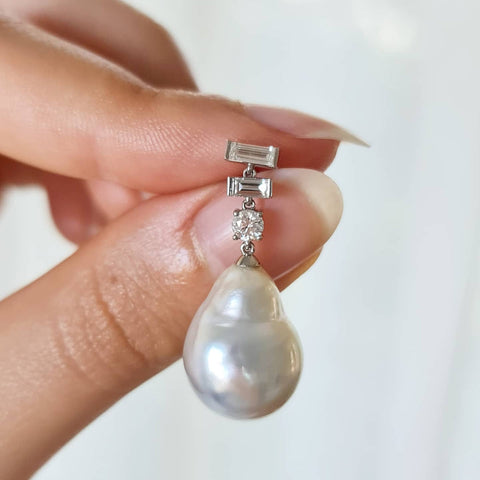 A close-up of a hand holding a Pearl Earring.