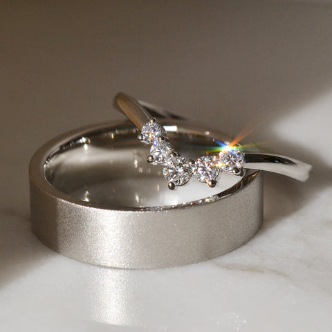 An arc diamond ring and a plain platinum wedding band
