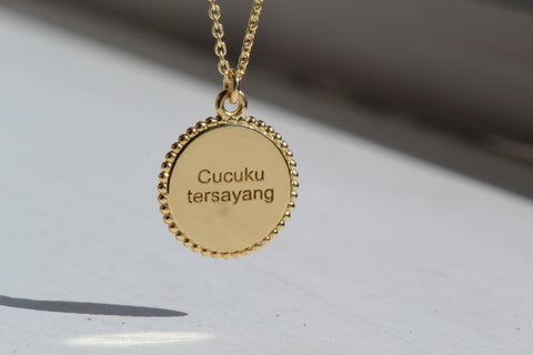 A close-up of a Necklace Engrave Classic Coin