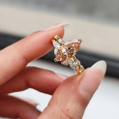 A close-up of a hand holding a Marquise Cut Sapphire Diamond Ring.