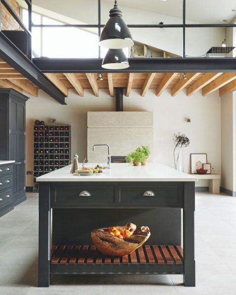 An industrial style shaker kitchen in front of a concrete fireplace. Kitchen by Tom Howley.