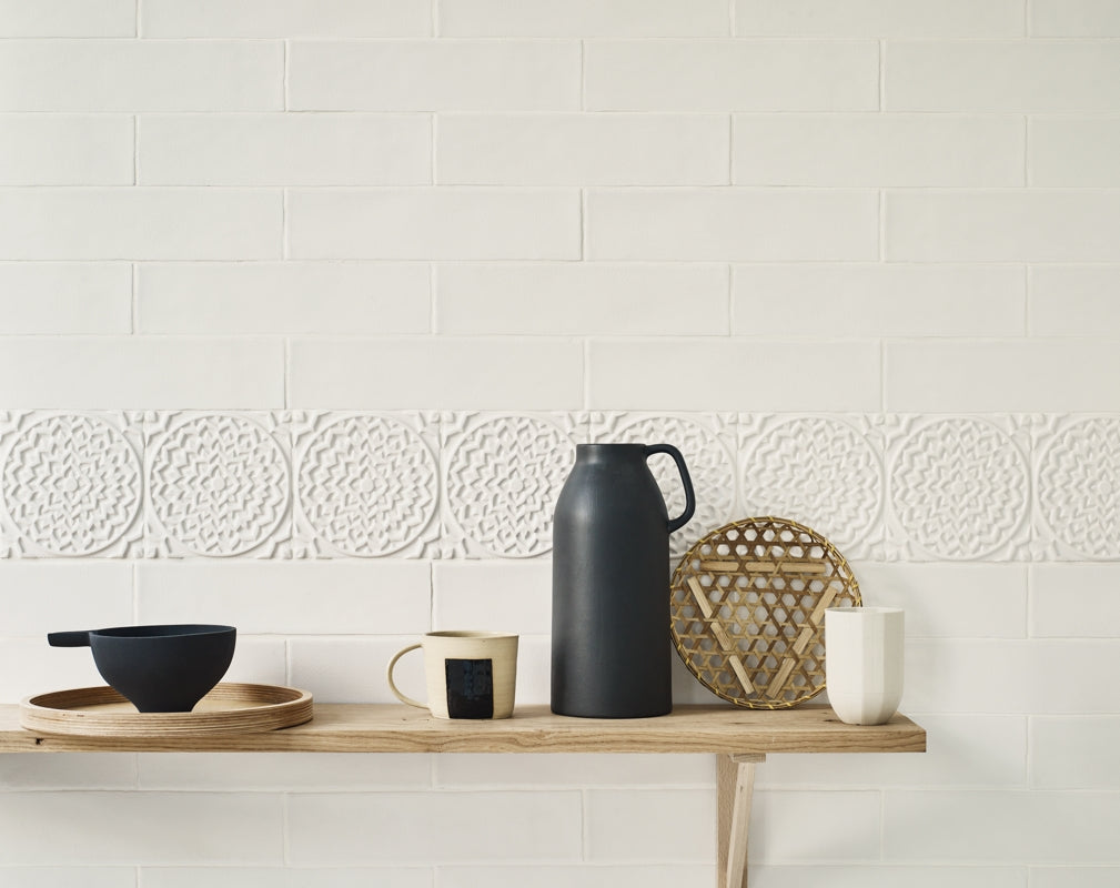 Osaka Kita tiles by Claybrook Studio add detail to a tiled wall behind displayed kitchen accessories