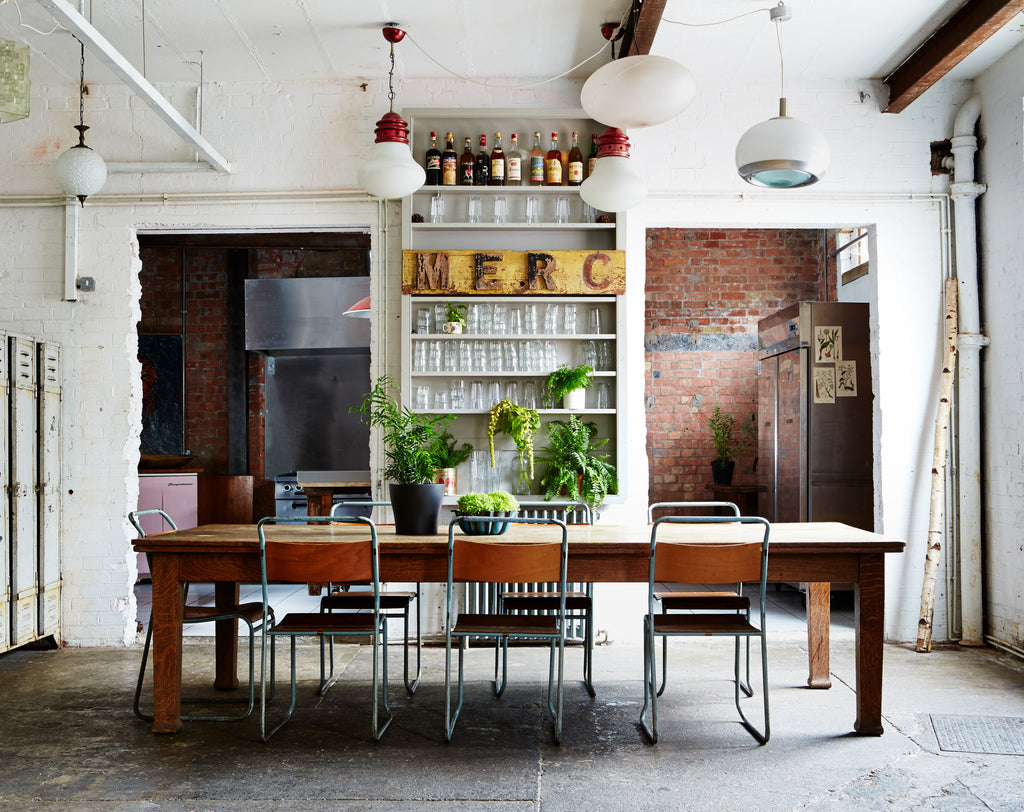 vintage industrial dining room with concrete floors and brick walls.