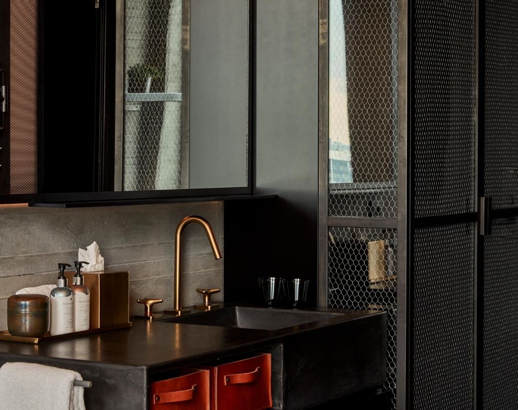 Sir Adam Hotel Amsterdam. Luxury bathroom in the guestroom features an industrial style mesh metal storage cabinet.