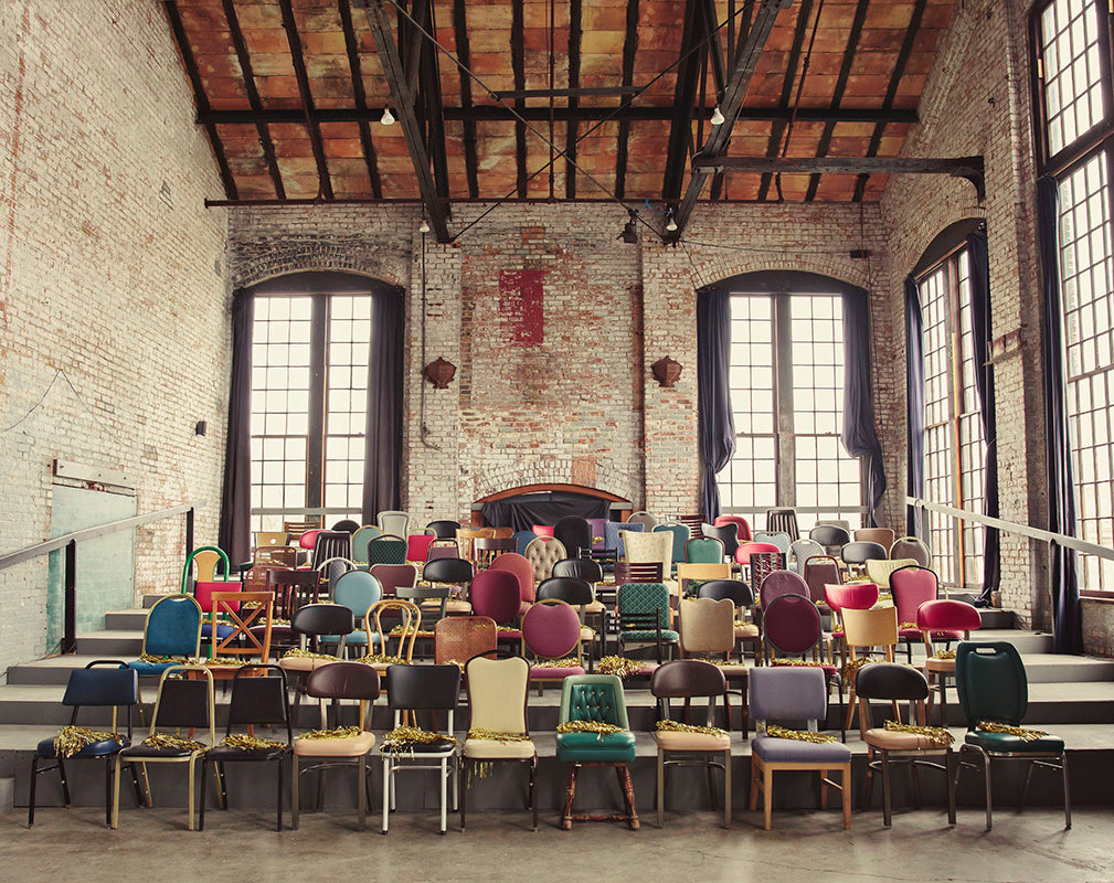 warehouse wedding venue with expansive warehouse windows, exposed beams and miss-matched vintage chairs.