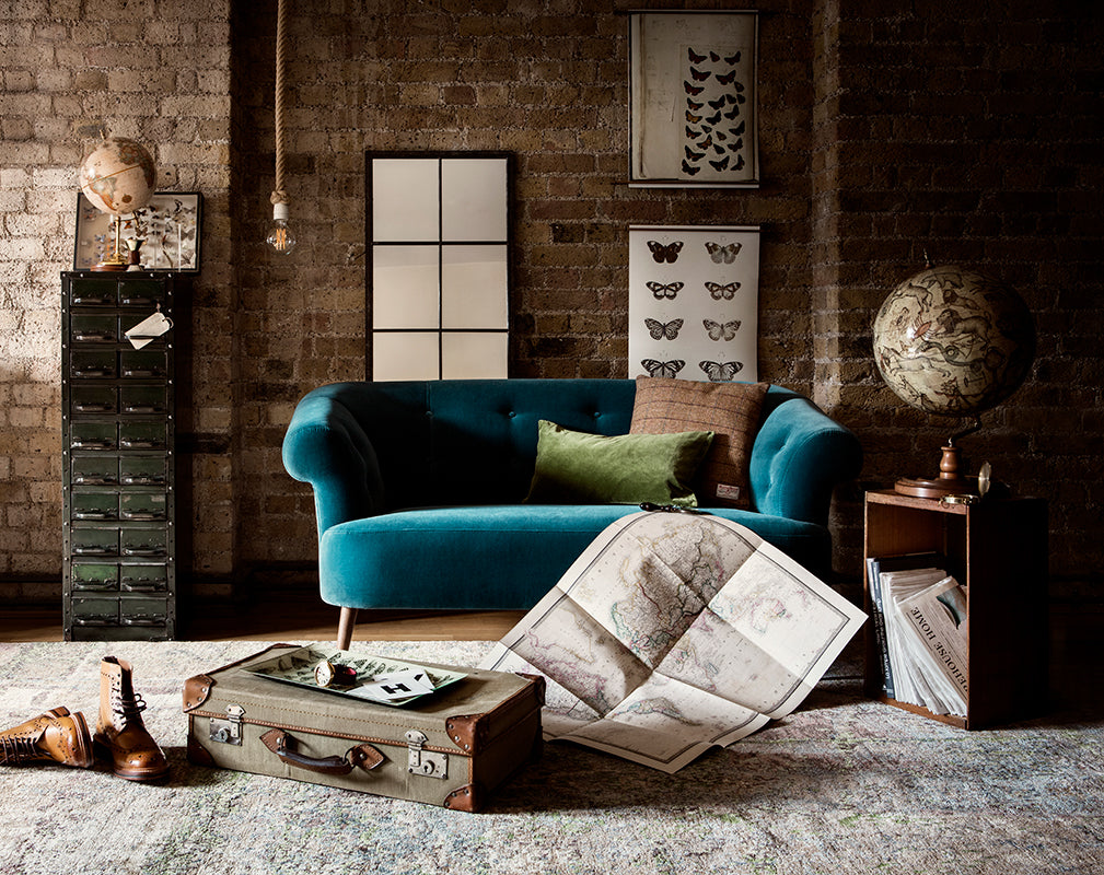 luxe industrial furniture in a contemporary warehouse conversion with exposed brick wall.