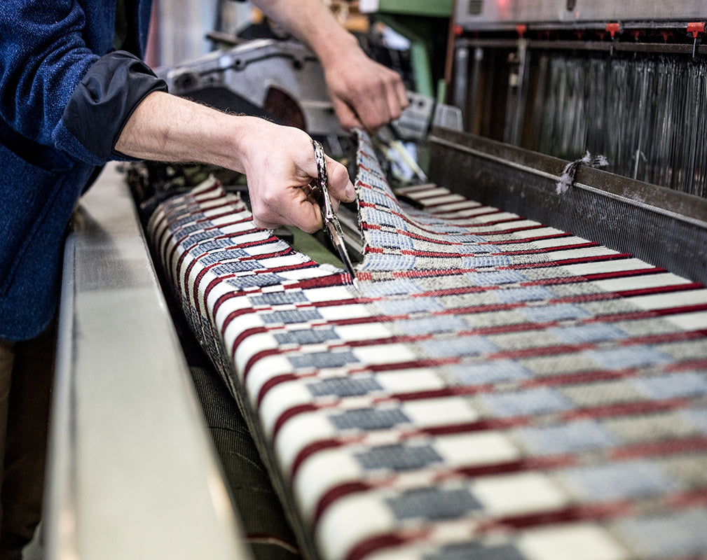 Woven cloth is cut from the loom at the london cloth company.