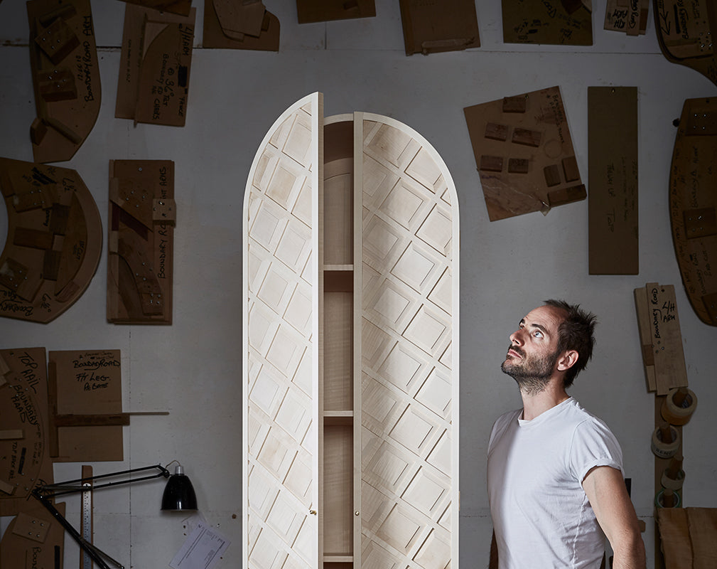 british designer gareth neal stands with the noble cabinet made from english sycamore with brass legs