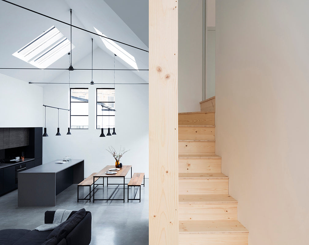 living room and pale timber staircase in defoe house by paper house project