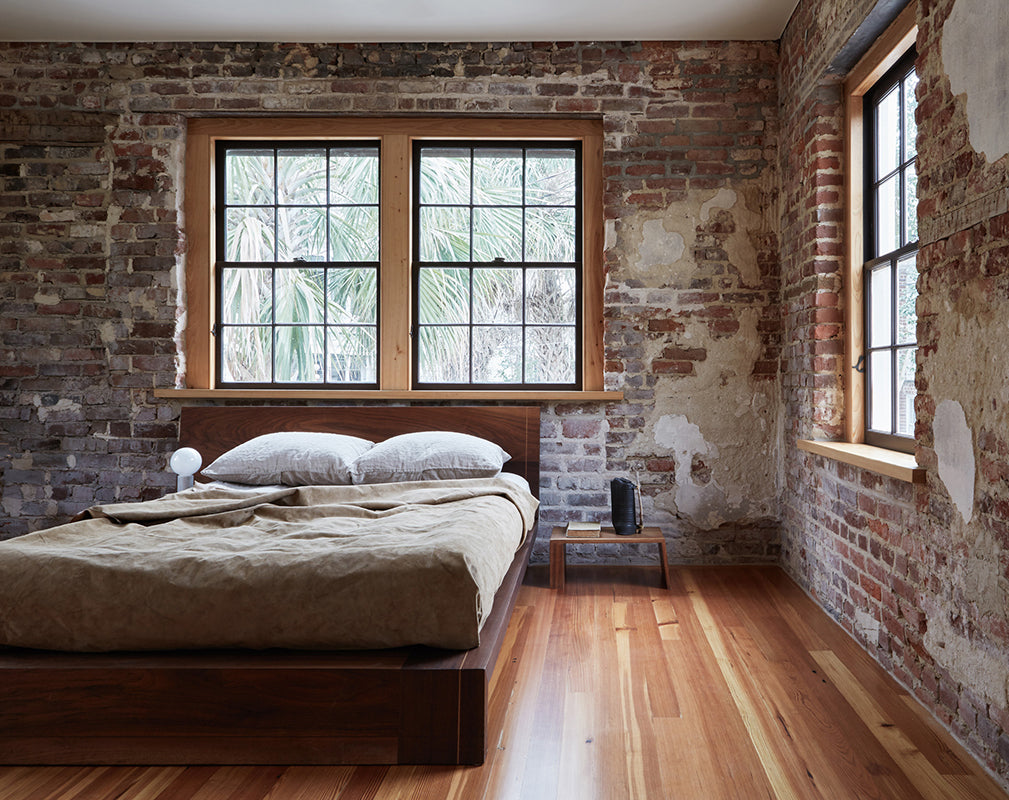 crittall style windows fill the bedroom of this converted carriage house with natural light