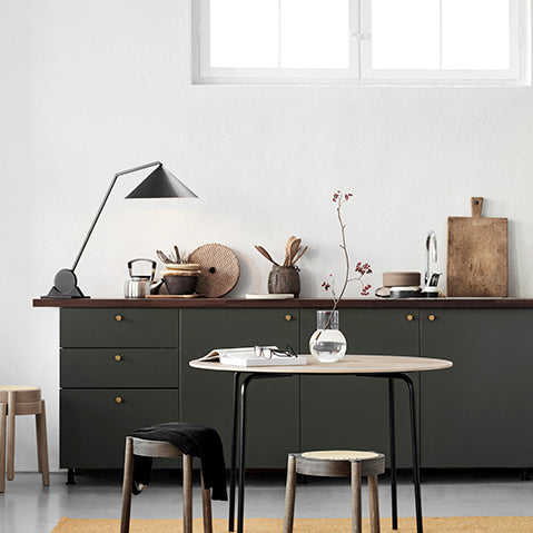 kitchen in an industrial building with olive green cupboards and warehouse window