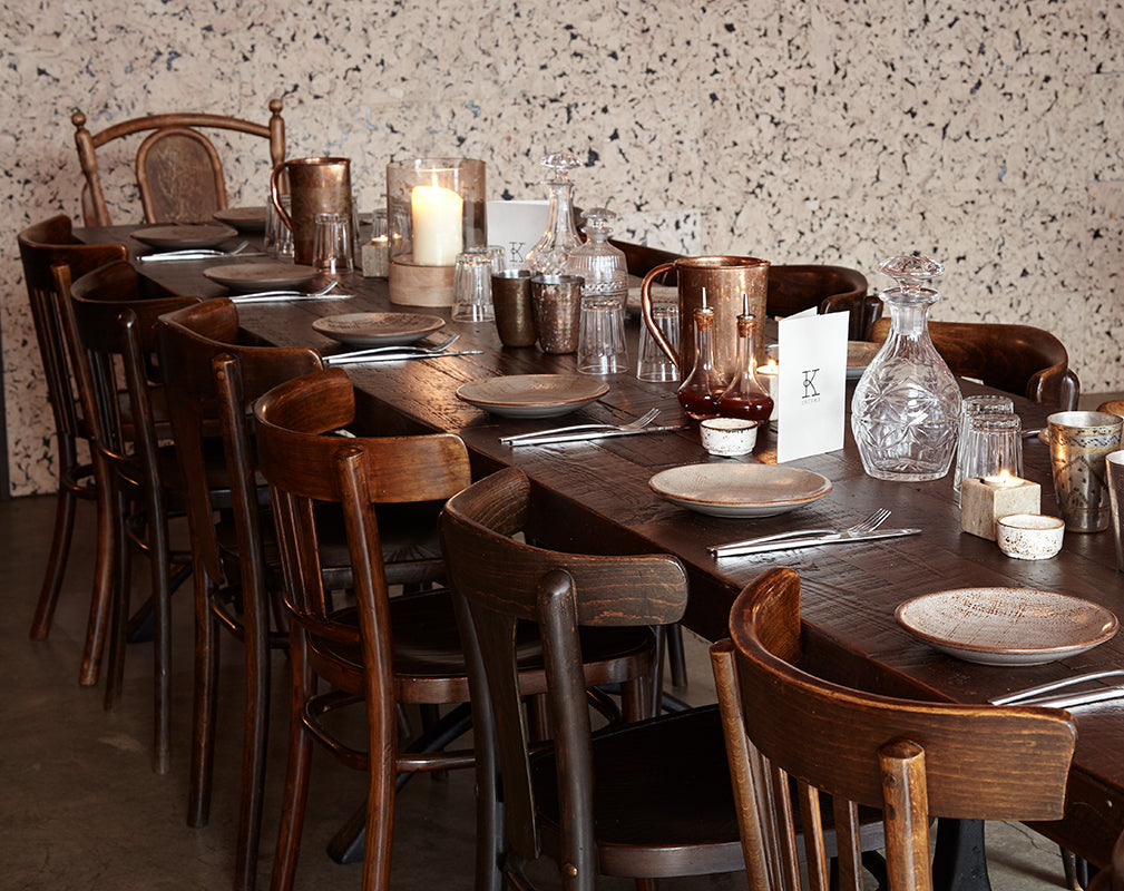 vintage bentwood style chairs are assembled around a communal dining table at kricket brixton