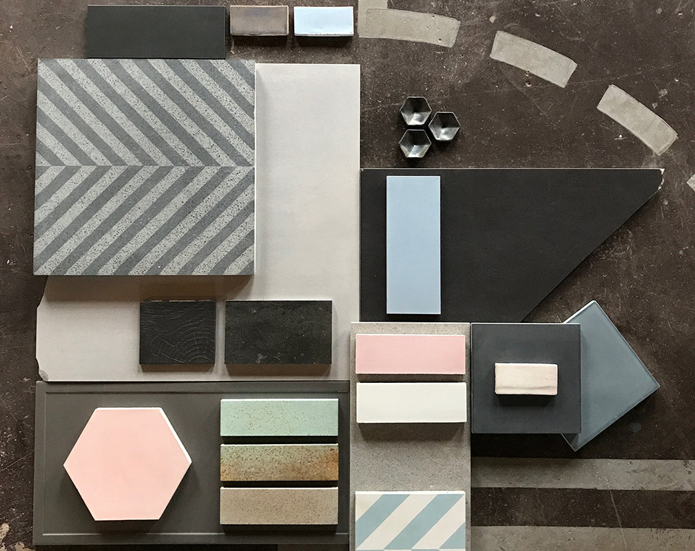 a collection of contemporary and industrial style floor and wall tiles on concrete floor.