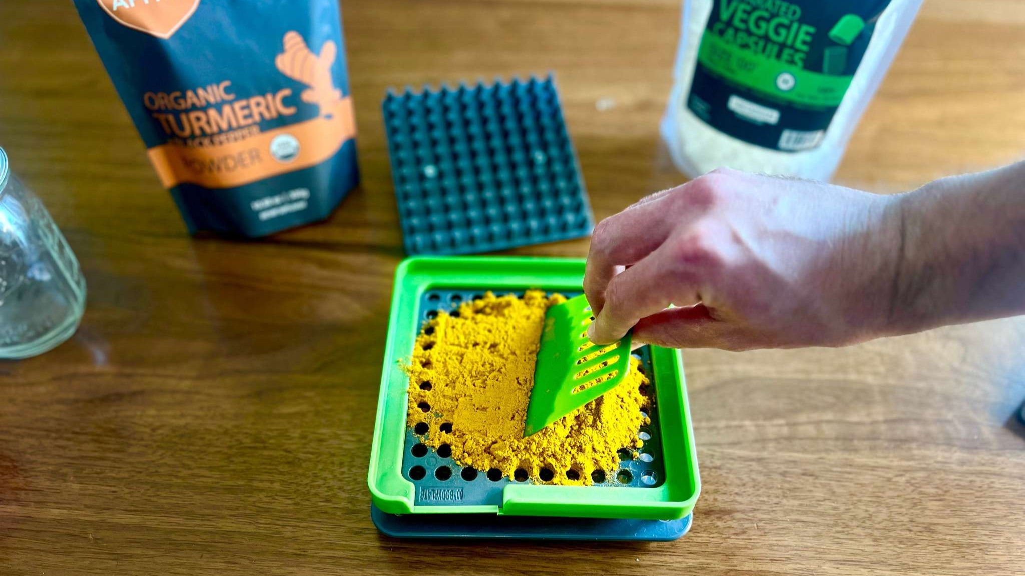 spreading turmeric powder into capsules