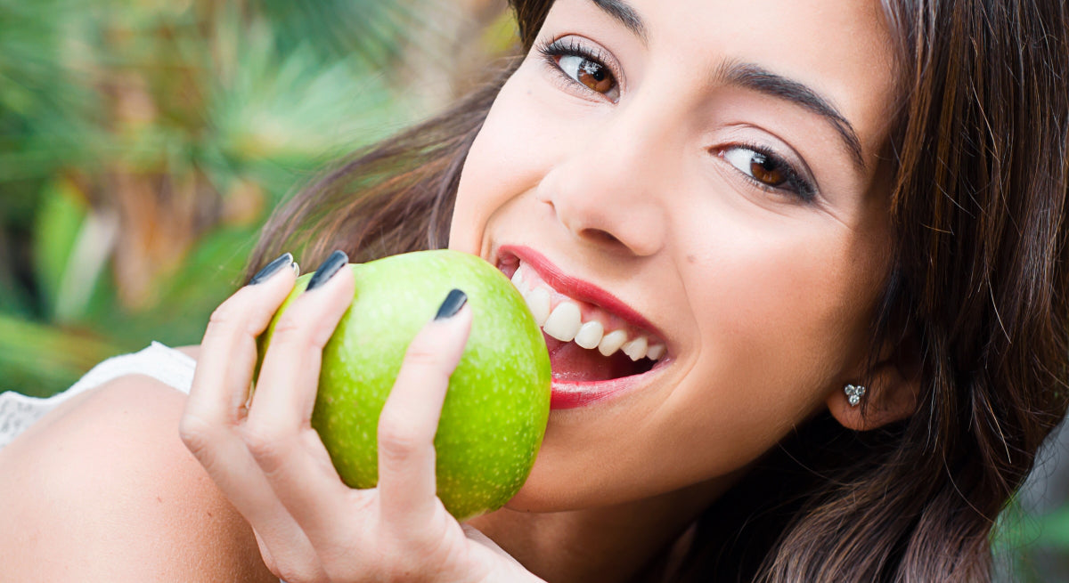 Woman Eating an Apple with Healthy Teeth